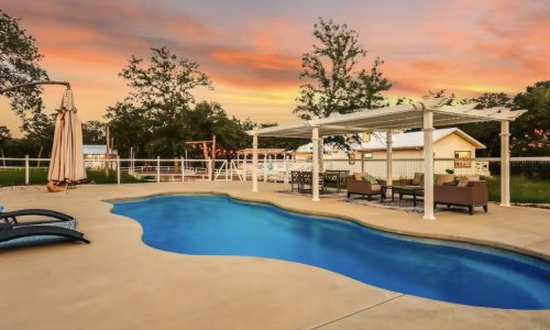 Pool at sunset with lounge chairs and pergola at Soulful Spaces
