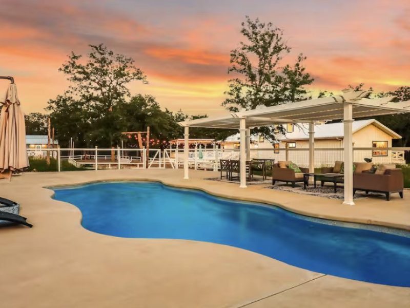 Pool at sunset with lounge chairs and pergola at Soulful Spaces